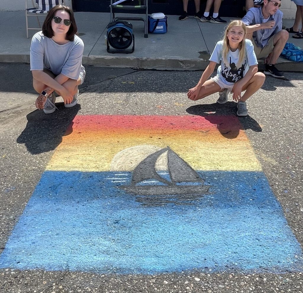 Kathryn and Madison posing with their chalk art